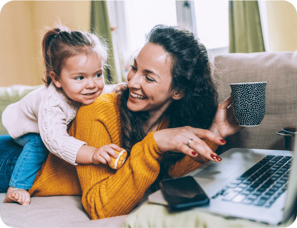 A smiling mother and her daughter use a laptop while enjoying the fastest internet speed from Glo Fiber