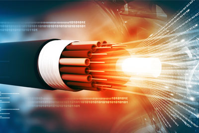 A magnified view of Fiber-Optic cables with data light emitting from them in a dark background as Glo Fiber technicians prepare to install them.