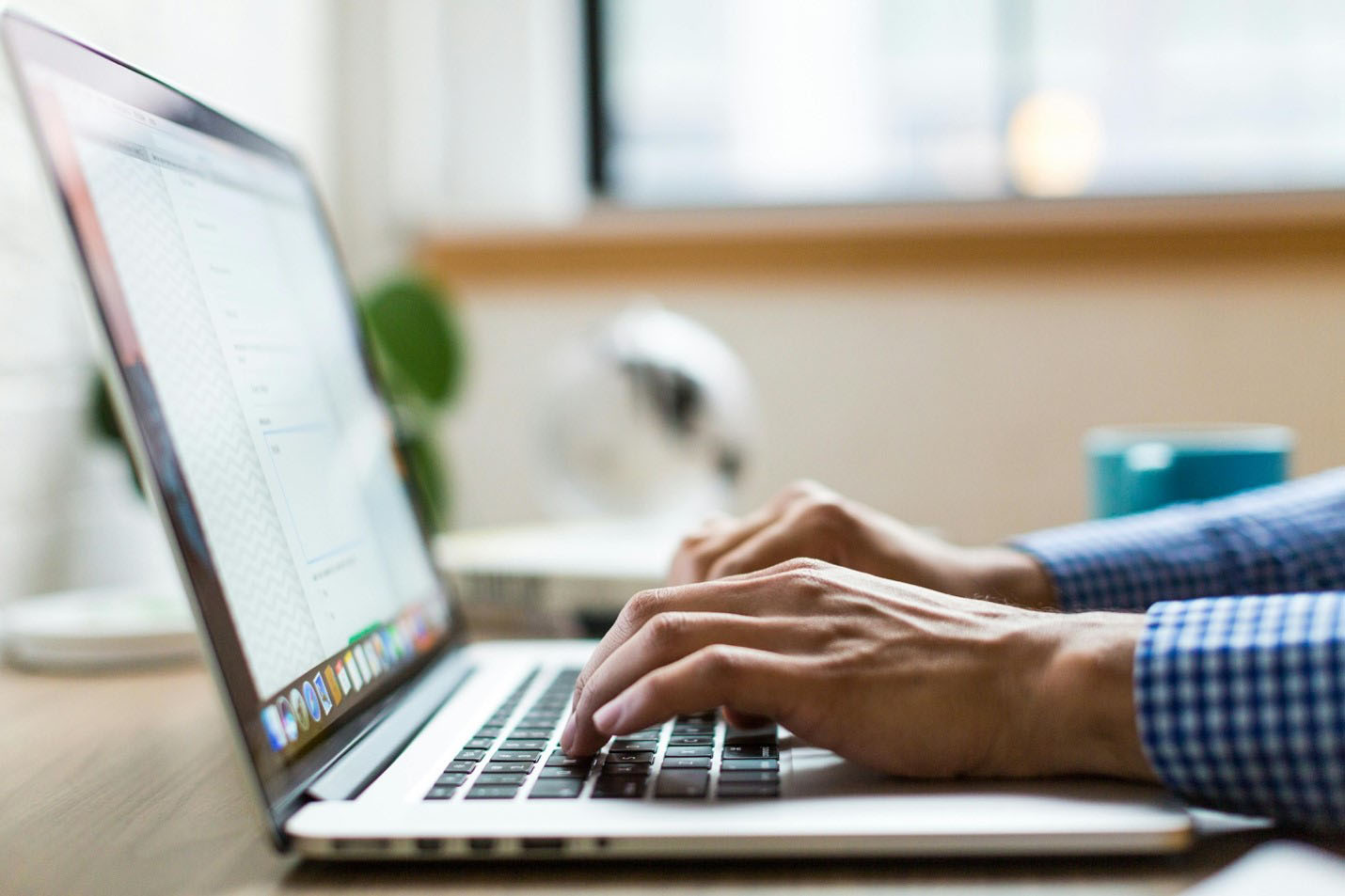 Business professional typing on a laptop computer