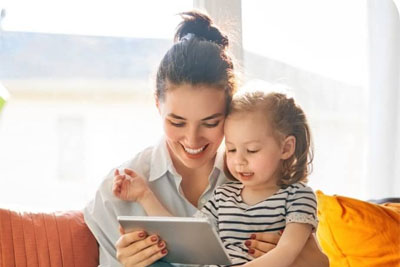 A mother playing on a tablet with her daughter