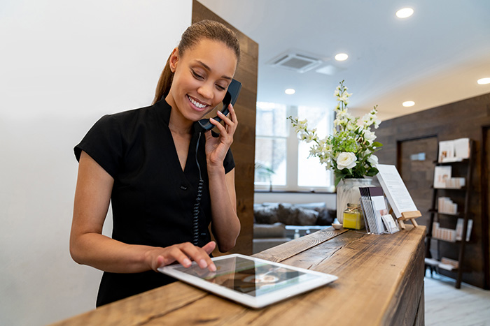 Woman talks on the phone at front desk of Sussex County Business